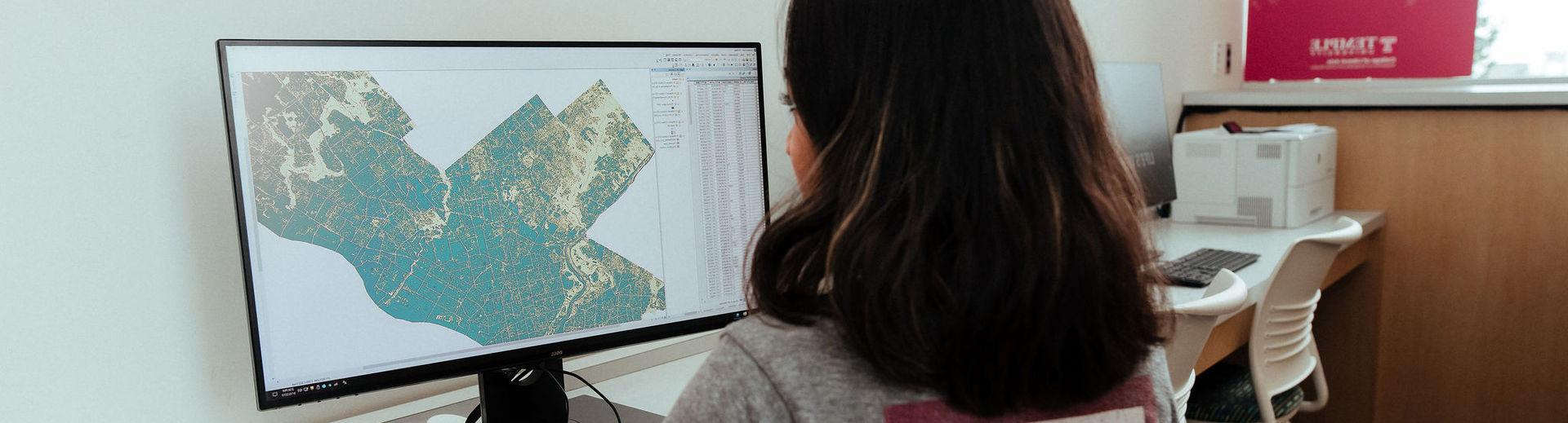 一位亿德体育的学生在电脑上学习地理信息系统.